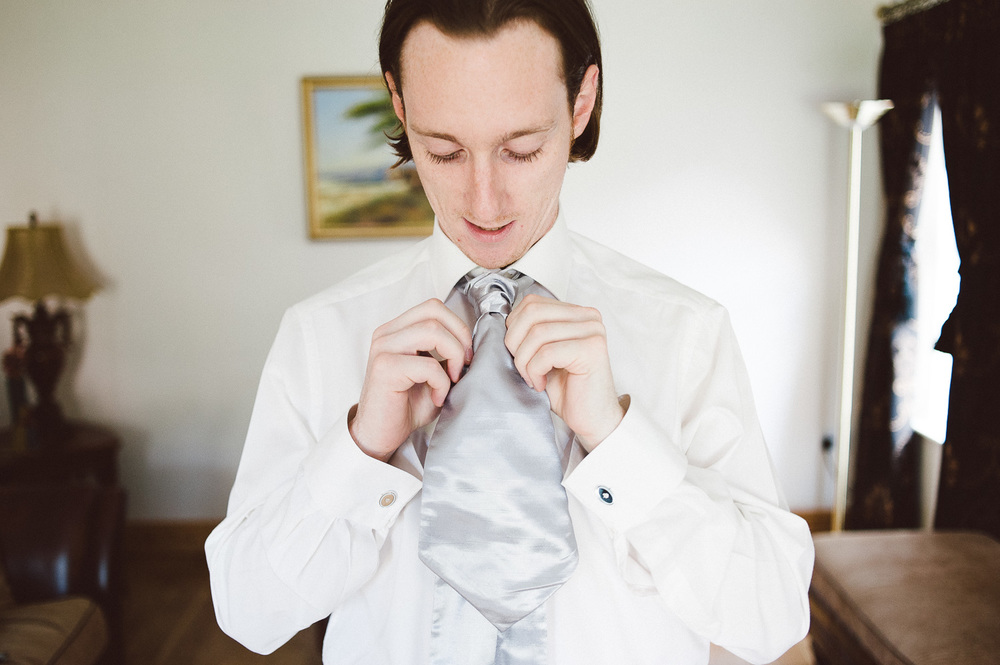 groom fixes his tie 