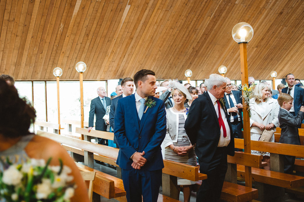 groom looks back at bride wedding aisle 