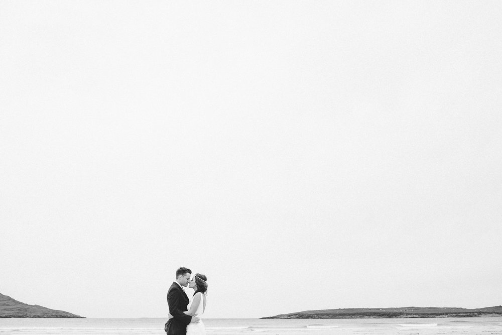 bride and groom kiss on a beach in donegal