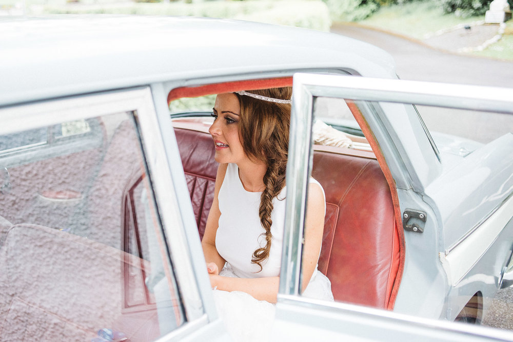 bride sits in wedding car
