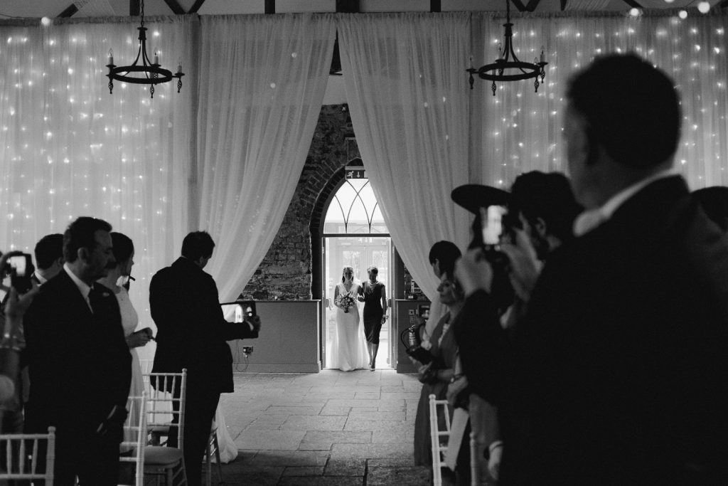 bride enters with her mother to walk up the aisle 