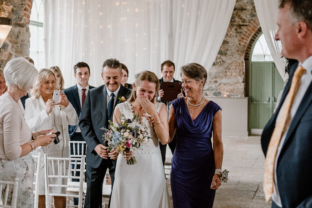bride cries as she walks up the aisle 