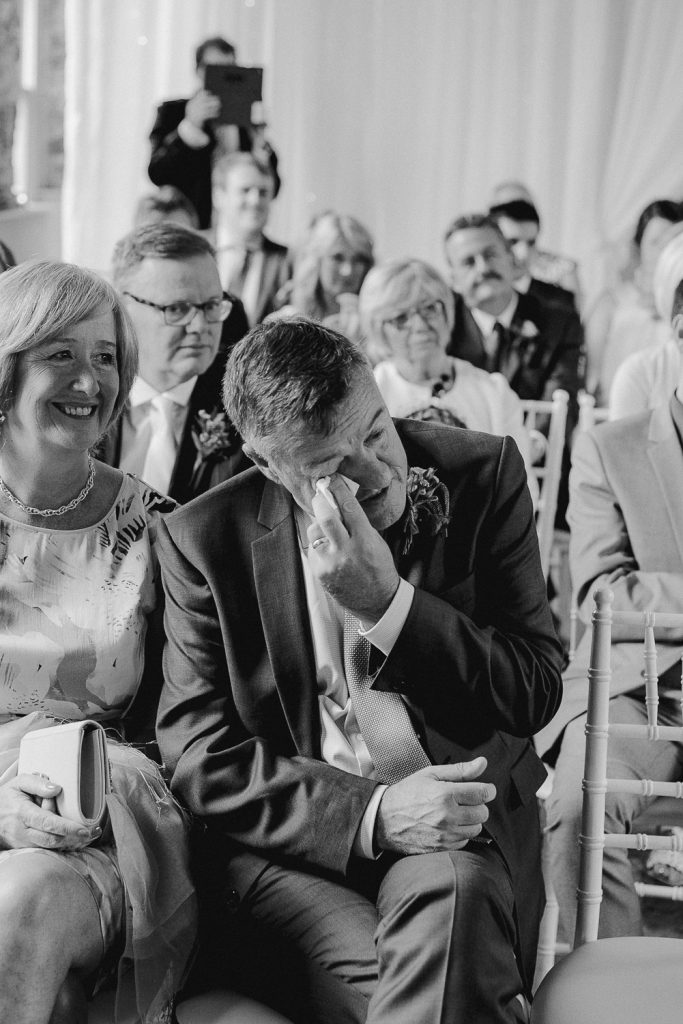 grooms father wipes tears away 