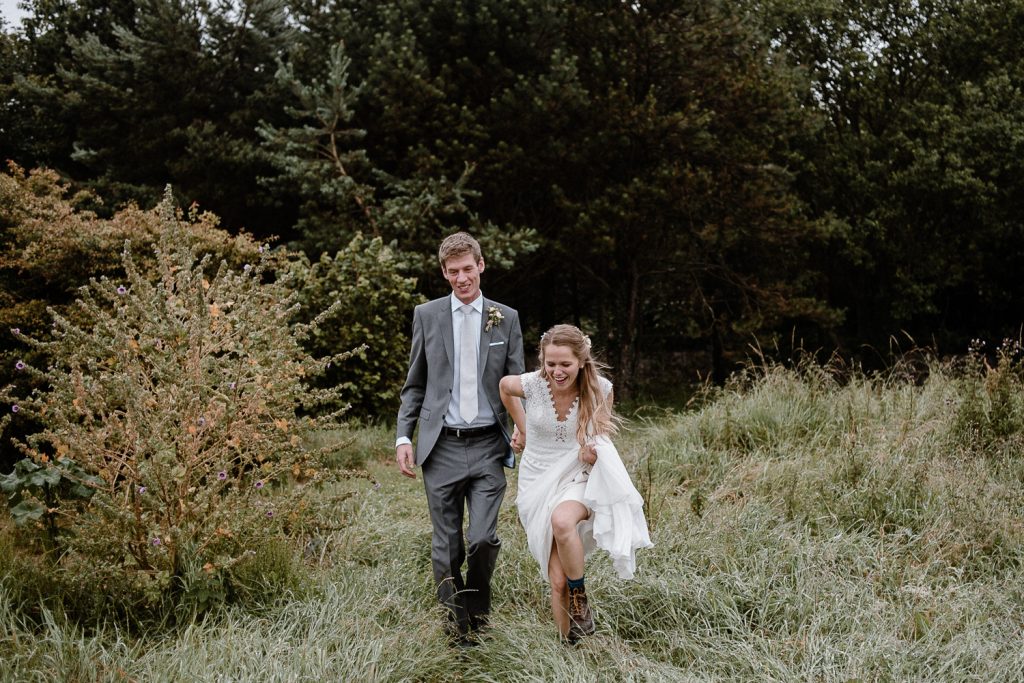 bride pulls groom into the grass 