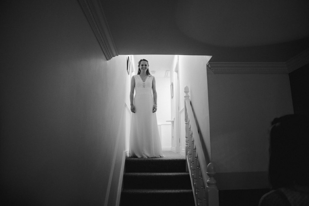 bride getting ready to walk down stairs 
