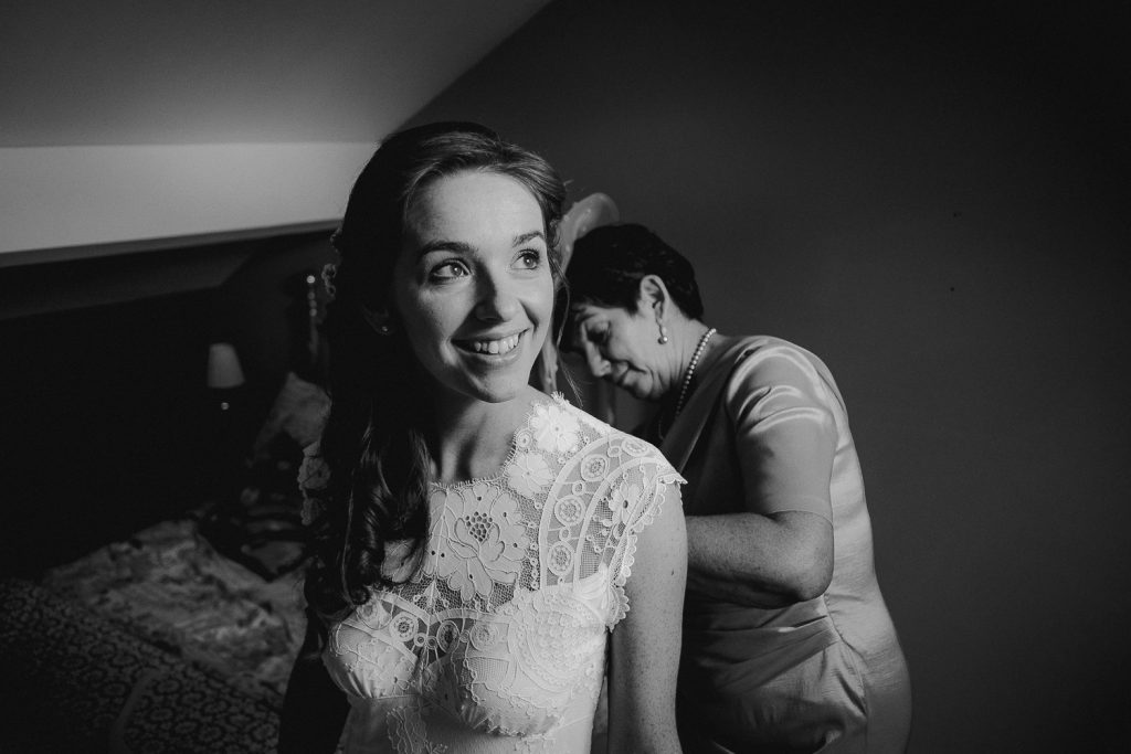 brides mum buttoning her dress