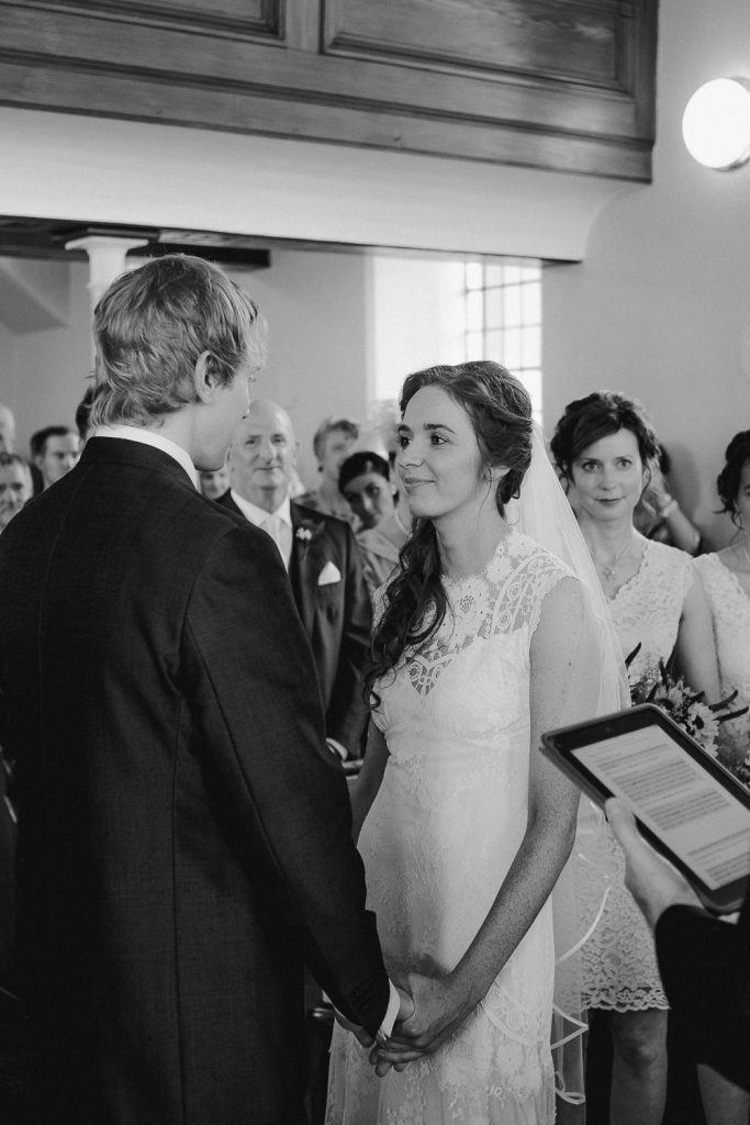bride standing looking at groom vows