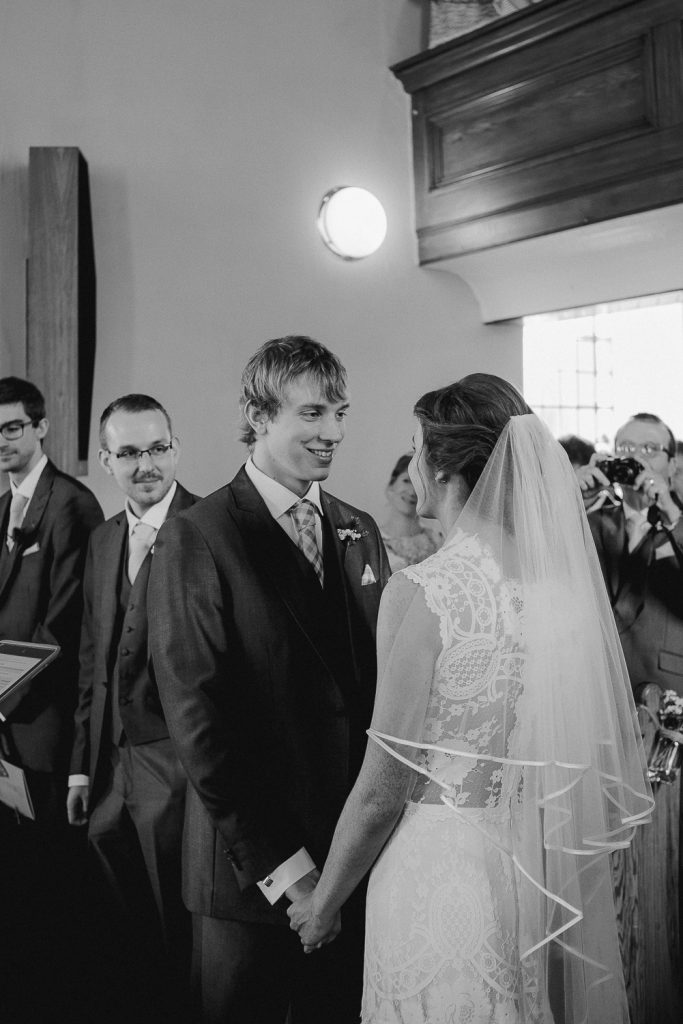 groom standing looking at bride