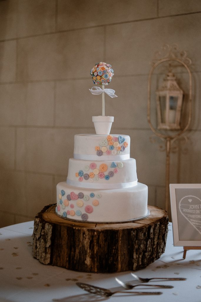 white wedding cake with button pattern