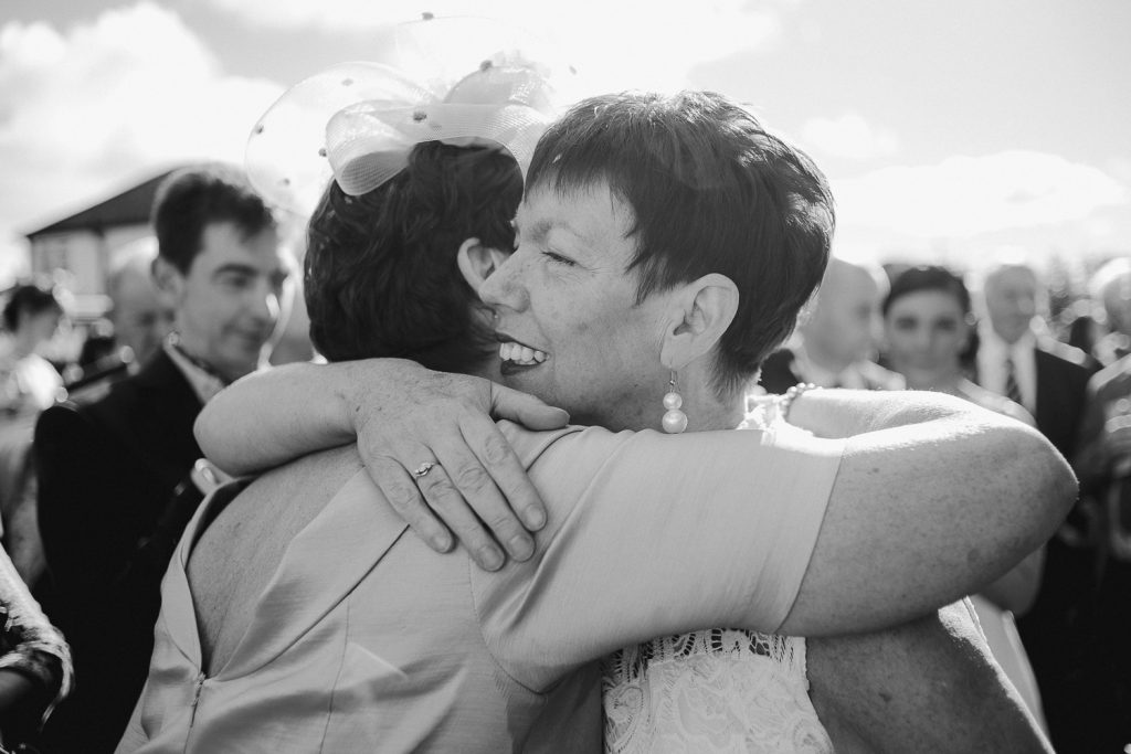 two weddings guests hugging