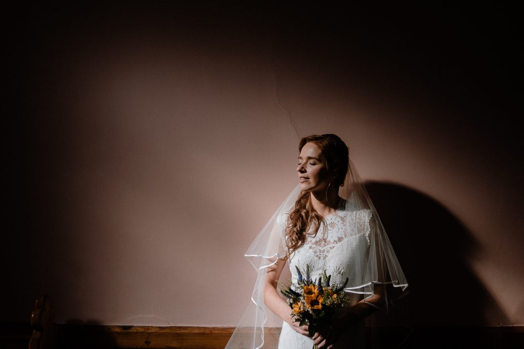 bride standing in light in church