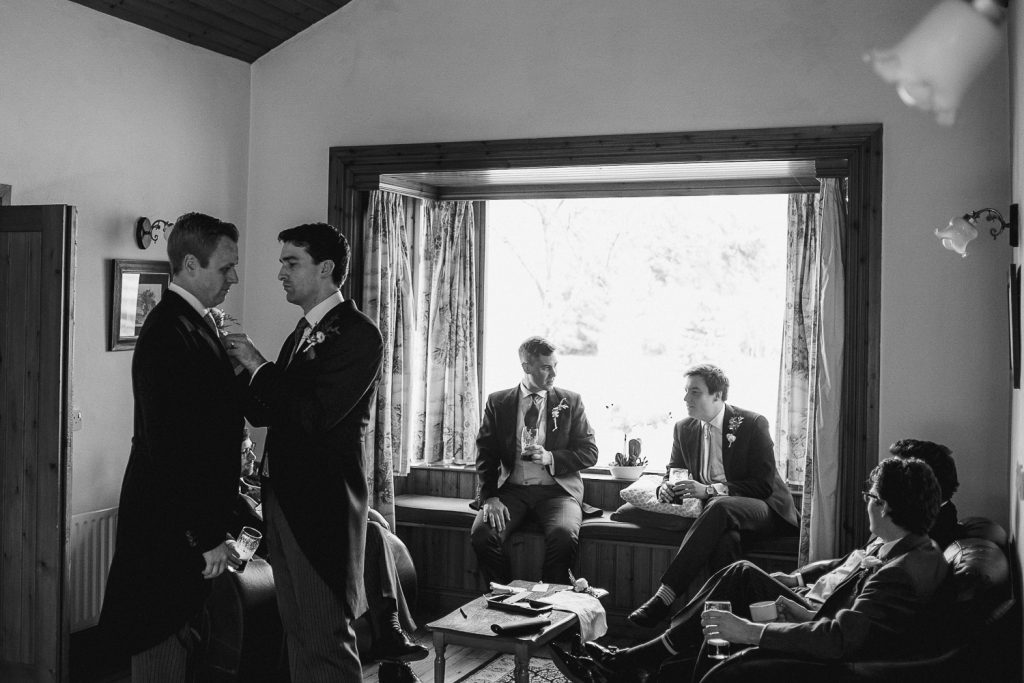 groomsmen sitting around a room chatting 