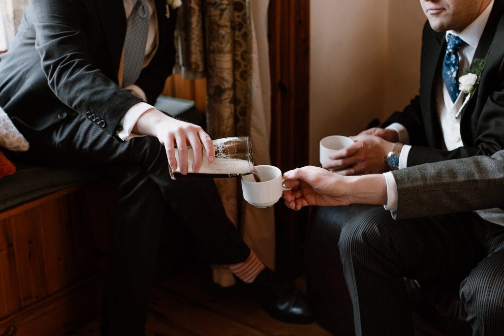 groomsman pouring beer into tea cup