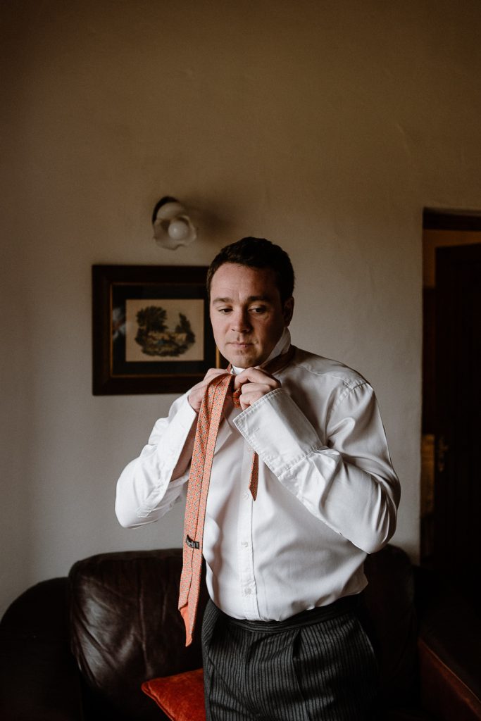 groom doing tie 