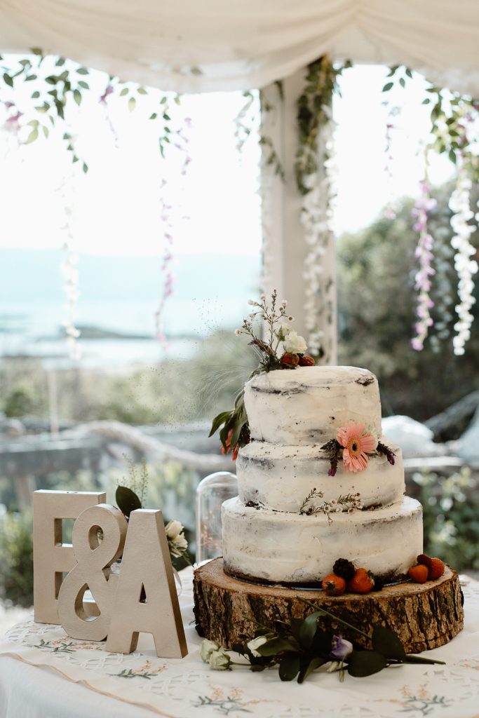 wedding cake sitting on a wooden log 