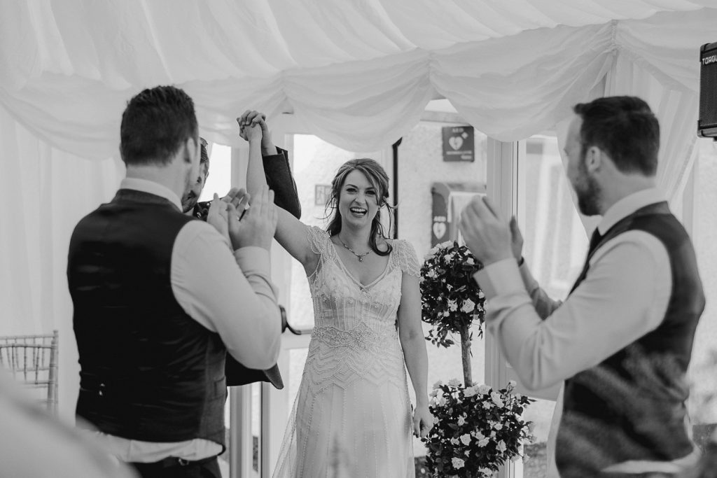 bride smiling and holding hand in the air 