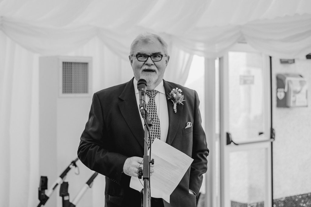 man wearing shirt and tie with glasses give a speech 