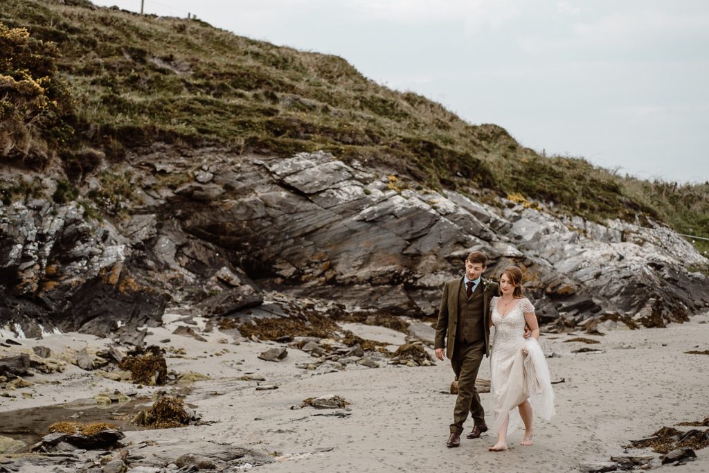 bride and groom walking on beach in donegal 