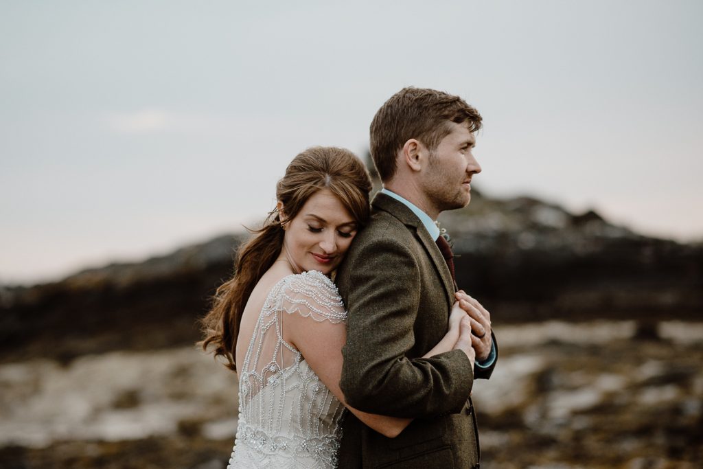 close up of bride hugging into grooms back 