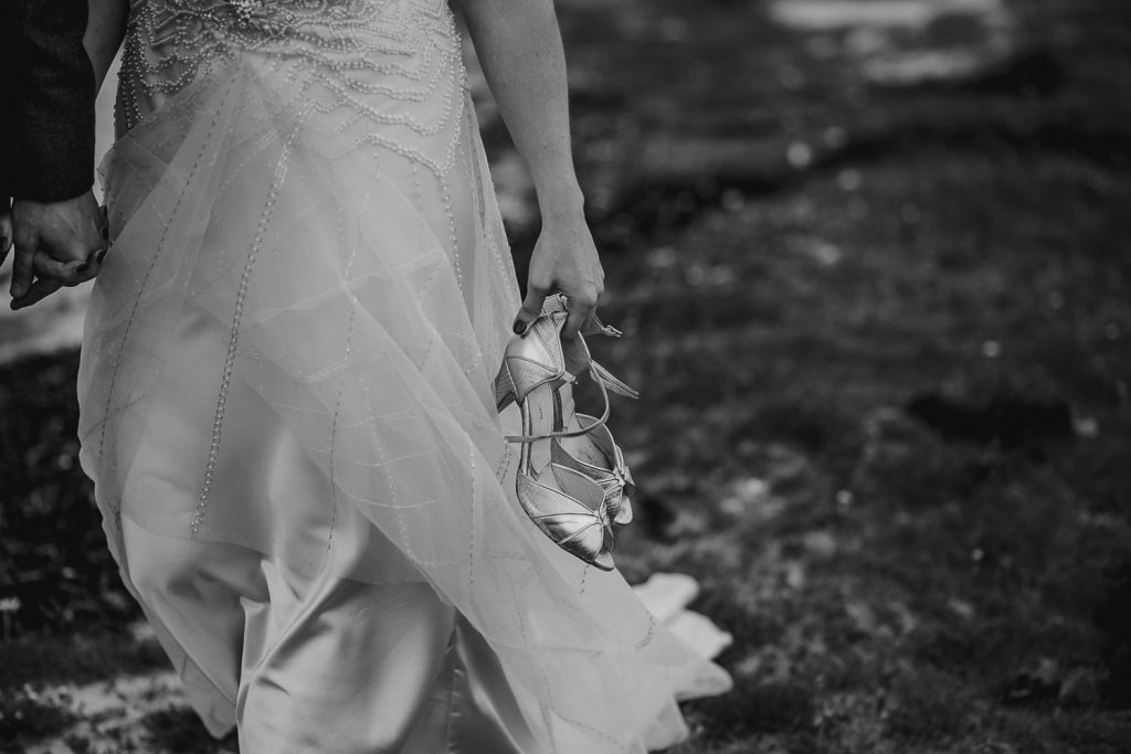 close up of bride holing she shoes and walking