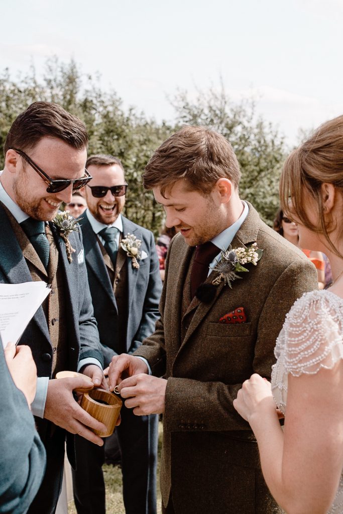 groom getting the wedding ring from best man