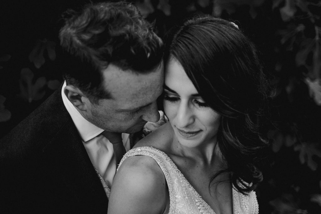 close up groom hugging into brides face