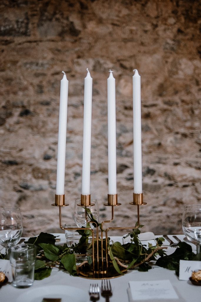 long white candles in gold holder