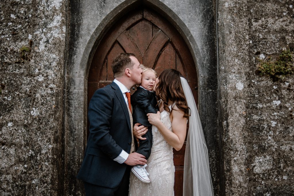 bride and groom kissing their on not he cheek