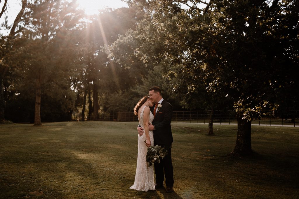 sunset bride rests head on grooms shoulder