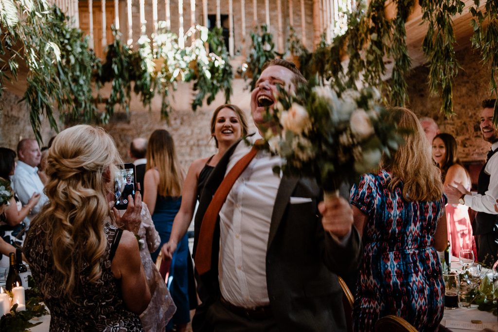wedding guests clapping in celebration of bride and groom entering the room