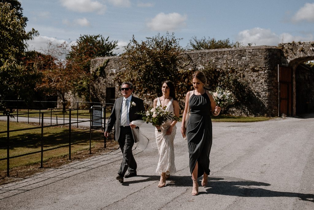 Bride walking to service with father at Blackwater castle wedding