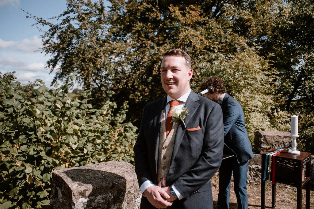 Groom smiles as he sees the bride for the first time