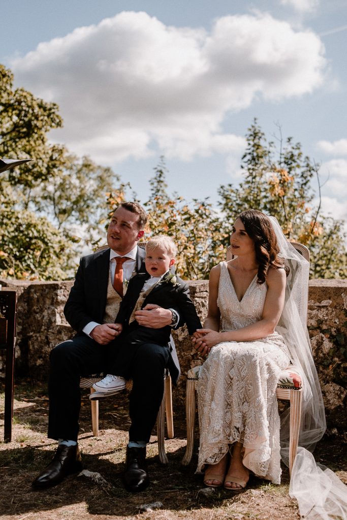 son sits on grooms knee