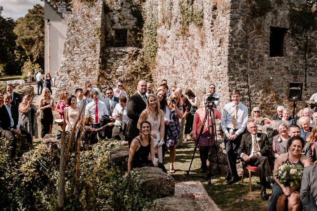 wedding guests taking in the outdoor service at blackwater castle