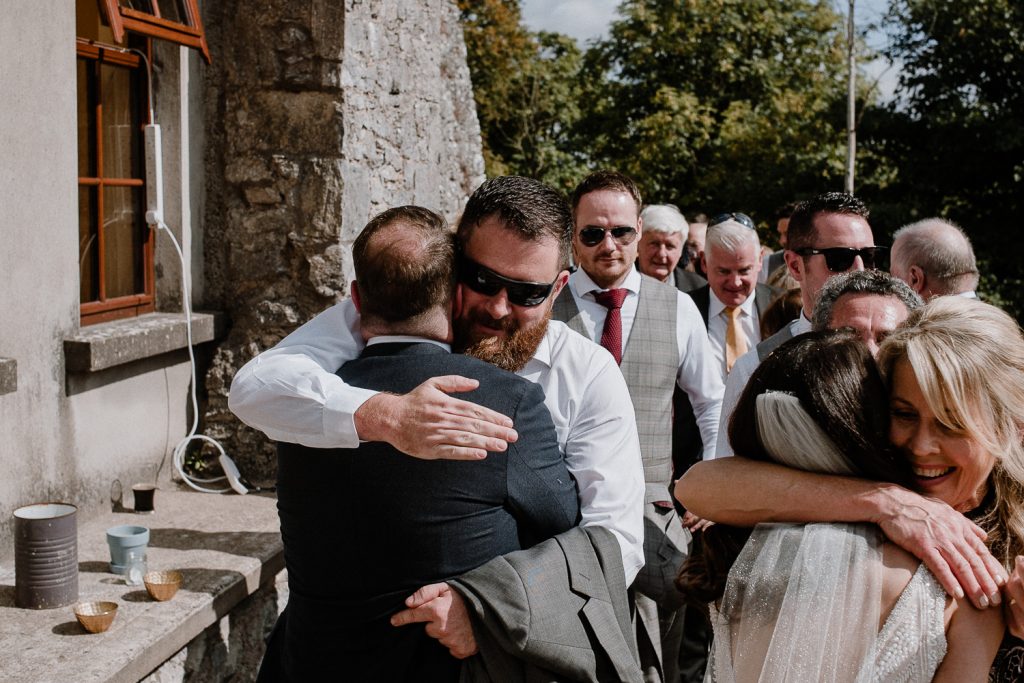 groom hugs wedding guests