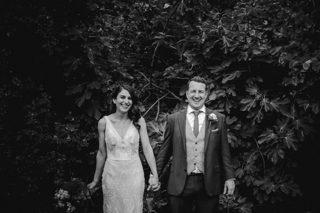 bride and groom holding hands laughing